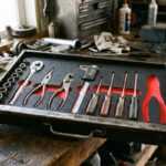 Tool kit with wrenches, pliers, screwdrivers and socket set in a black case on a workbench