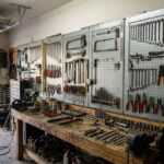 Garage workshop with tool pegboards, workbench, and open overhead garage door